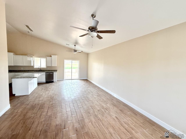 unfurnished living room featuring vaulted ceiling, baseboards, light wood-type flooring, and a sink