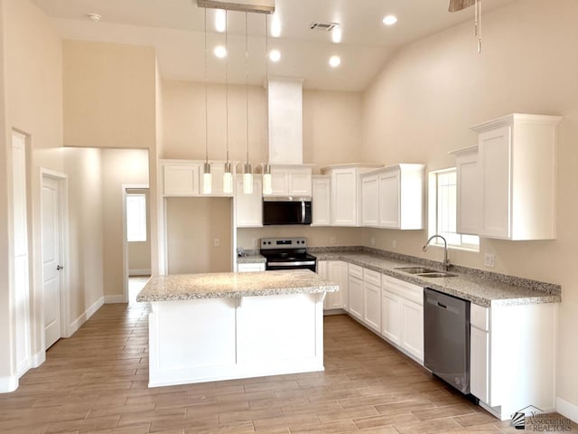 kitchen featuring visible vents, high vaulted ceiling, a sink, a kitchen island, and appliances with stainless steel finishes