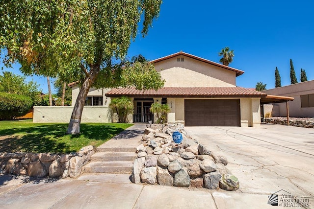mediterranean / spanish-style house with a front yard, a tiled roof, a garage, concrete driveway, and stucco siding