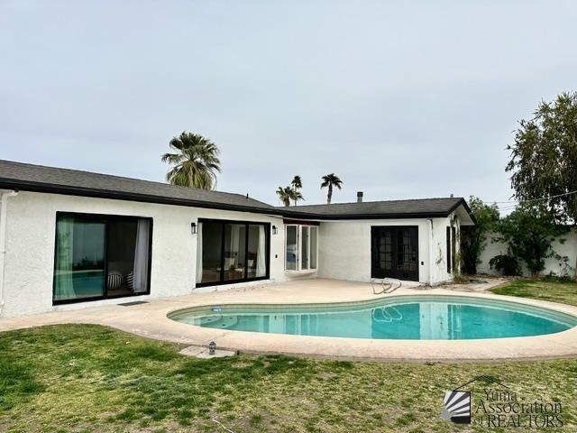 rear view of property with a lawn and a patio