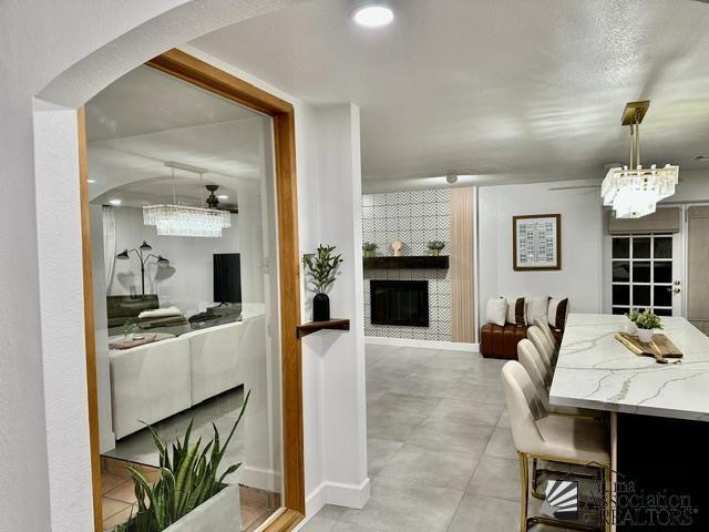 dining area featuring a large fireplace and ceiling fan