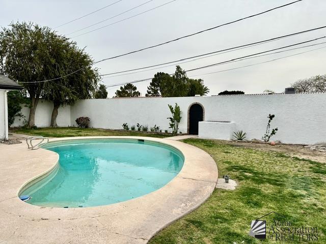 view of pool featuring a yard