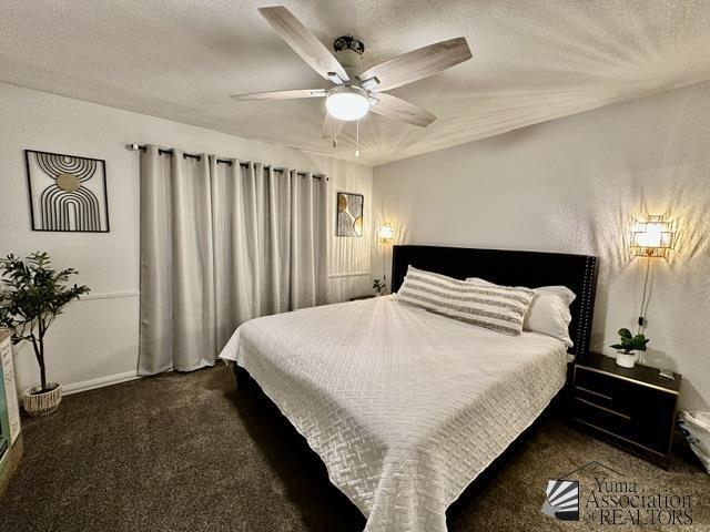 carpeted bedroom with ceiling fan and a textured ceiling