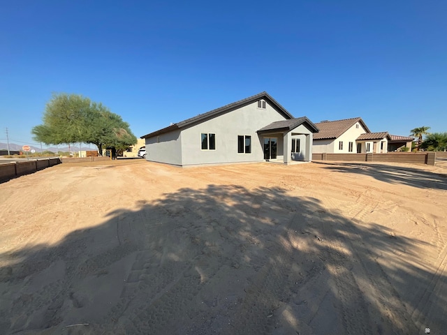 view of front of house featuring fence and stucco siding