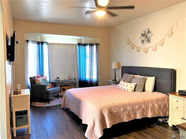 bedroom with multiple windows, dark wood-type flooring, and ceiling fan