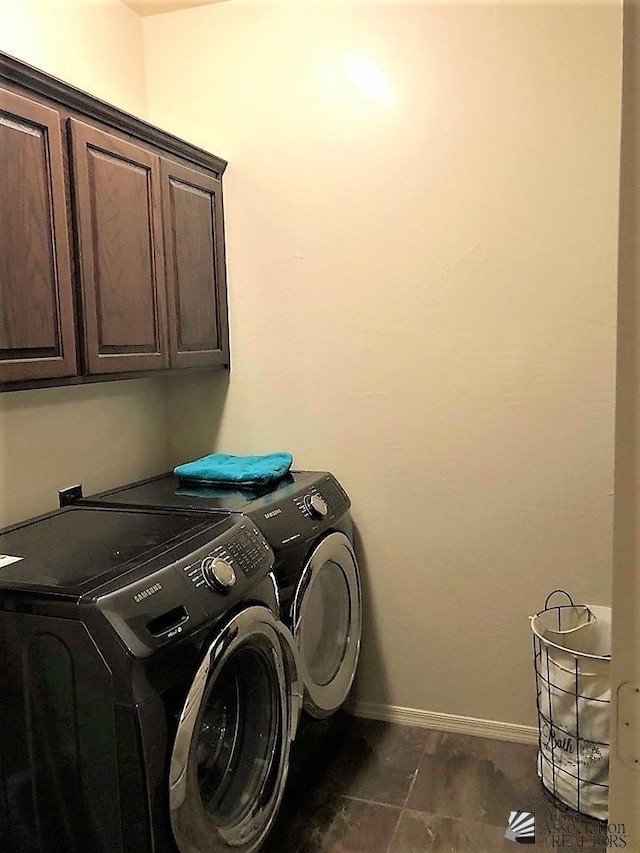 clothes washing area with cabinets and washing machine and dryer