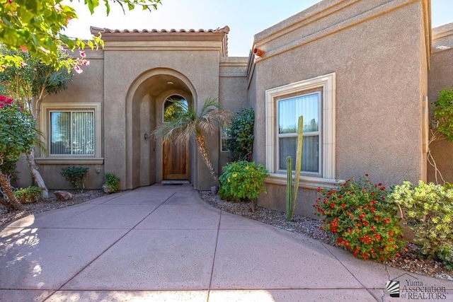 view of exterior entry with a patio