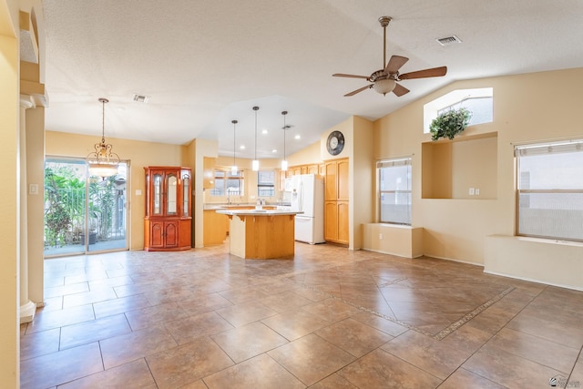 kitchen with decorative light fixtures, white refrigerator, ceiling fan, and vaulted ceiling