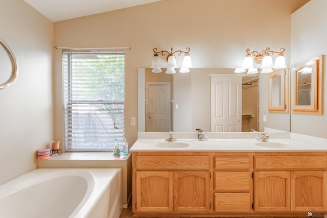 bathroom with a washtub, vanity, and vaulted ceiling