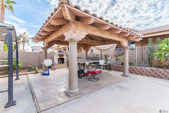 view of patio / terrace featuring a gazebo and exterior fireplace