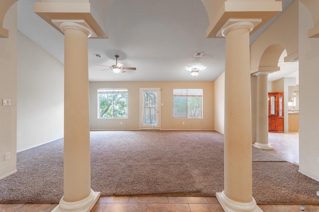 unfurnished living room featuring ceiling fan, light carpet, and decorative columns