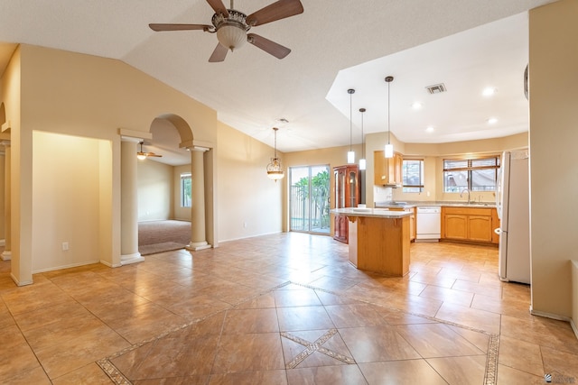 kitchen featuring ornate columns, ceiling fan, a center island, sink, and white appliances