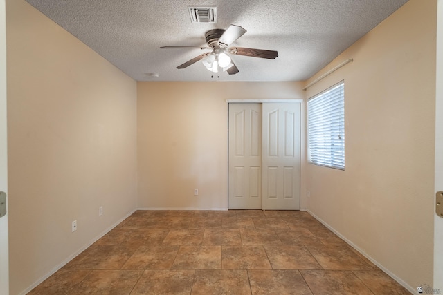 unfurnished bedroom featuring ceiling fan, a closet, and a textured ceiling