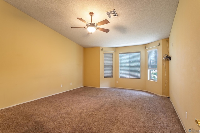 carpeted spare room with ceiling fan and a textured ceiling