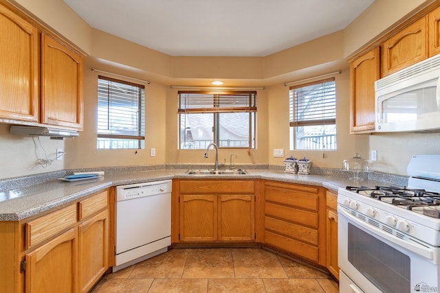 kitchen featuring light tile patterned flooring, white appliances, a wealth of natural light, and sink