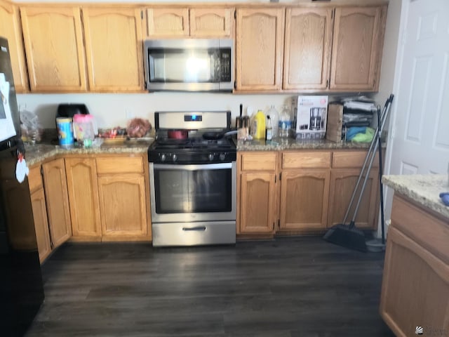 kitchen featuring dark hardwood / wood-style floors, light brown cabinets, light stone countertops, and stainless steel appliances