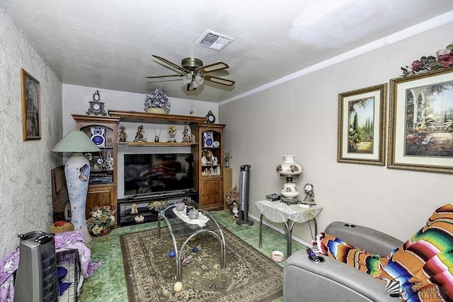 living room with ornamental molding, a textured ceiling, and ceiling fan