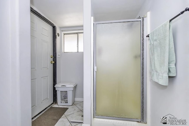 bathroom with a shower with shower door and tile patterned flooring