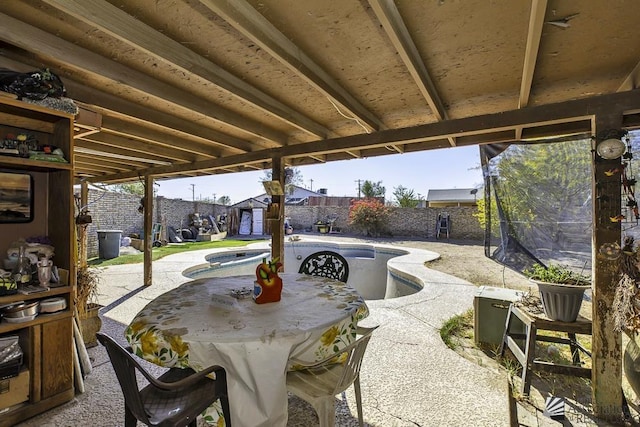 view of patio / terrace with a fenced in pool and a shed