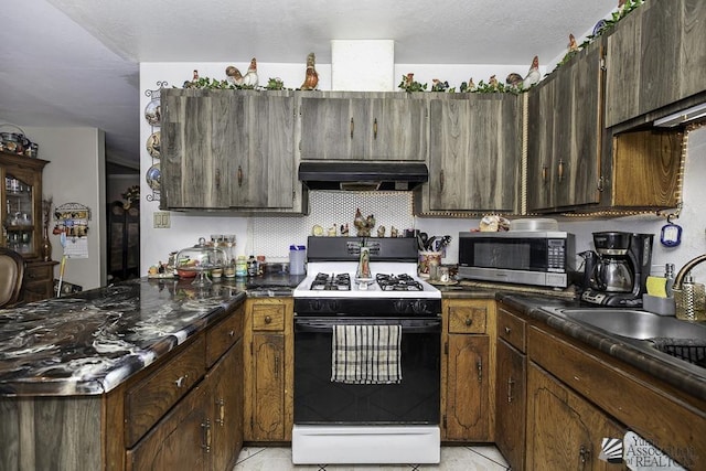 kitchen featuring dark brown cabinetry, sink, gas stove, light tile patterned floors, and decorative backsplash