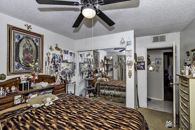 carpeted bedroom with ceiling fan, a textured ceiling, and a closet