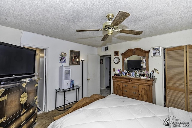 carpeted bedroom with ceiling fan and a textured ceiling