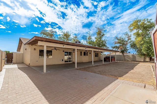 back of property featuring ceiling fan and a patio