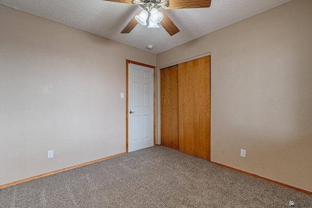 unfurnished bedroom with carpet flooring, ceiling fan, a closet, and a textured ceiling