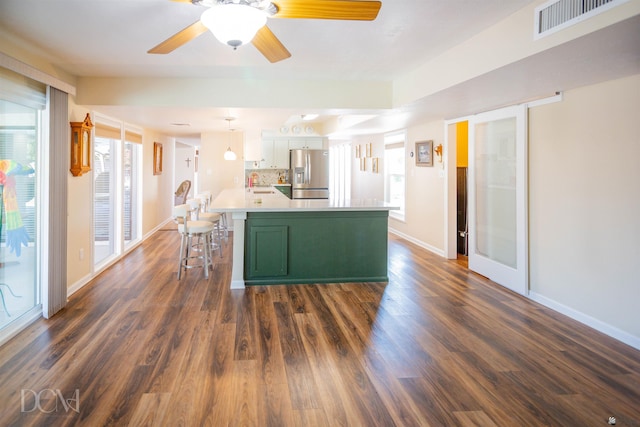 kitchen featuring dark wood-style flooring, a sink, visible vents, green cabinets, and stainless steel fridge