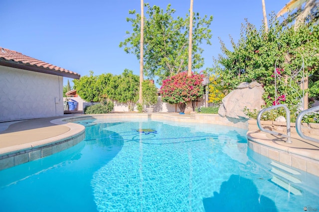 outdoor pool with a fenced backyard