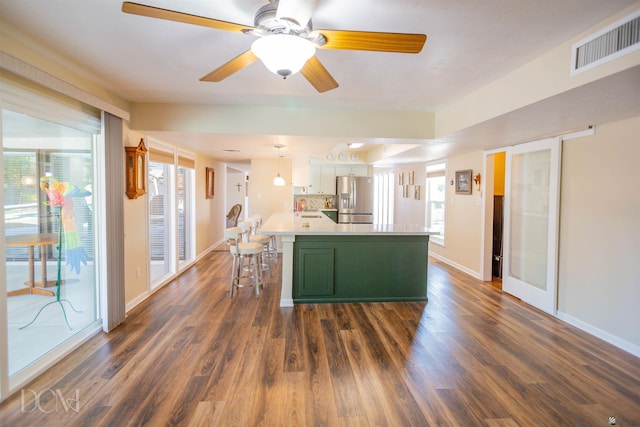 kitchen featuring dark wood finished floors, visible vents, a sink, green cabinetry, and stainless steel fridge with ice dispenser