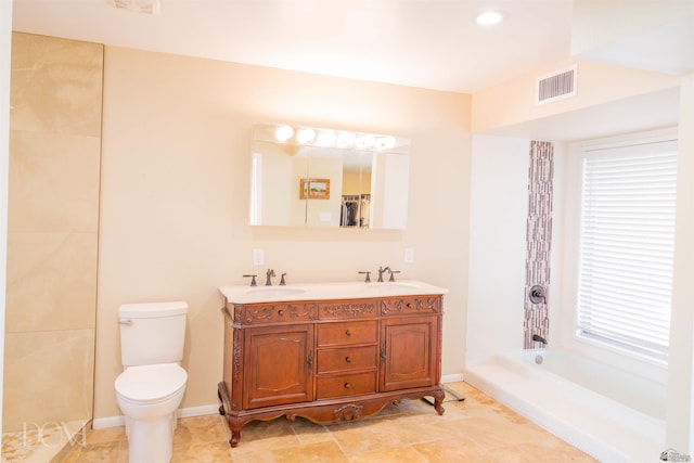 bathroom with double vanity, visible vents, toilet, a sink, and baseboards