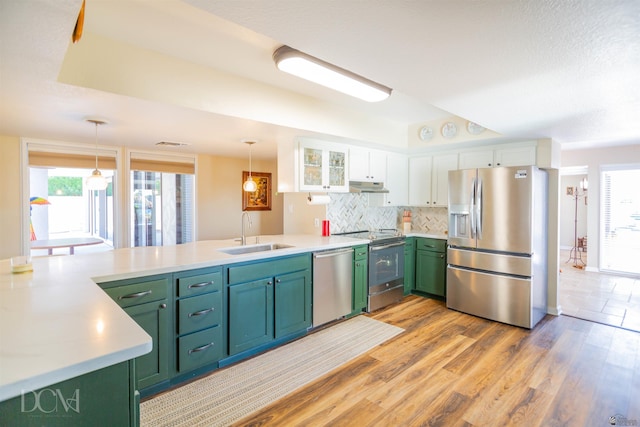 kitchen with white cabinets, green cabinets, stainless steel appliances, and a sink