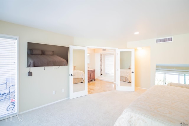 carpeted bedroom featuring ensuite bath, baseboards, visible vents, and french doors