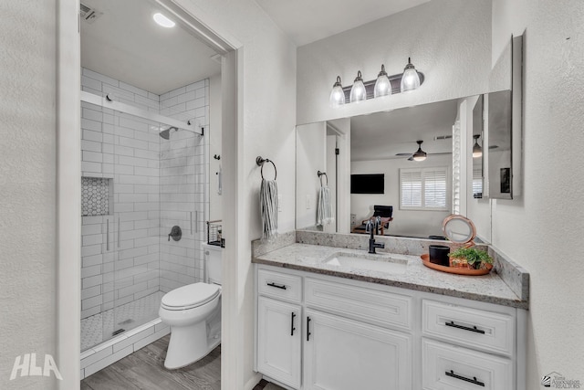 bathroom featuring toilet, ensuite bath, wood finished floors, vanity, and a shower stall