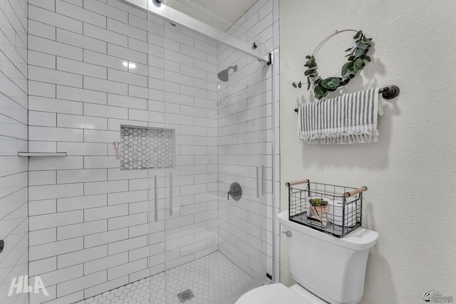 full bathroom with toilet, a shower stall, and a textured wall