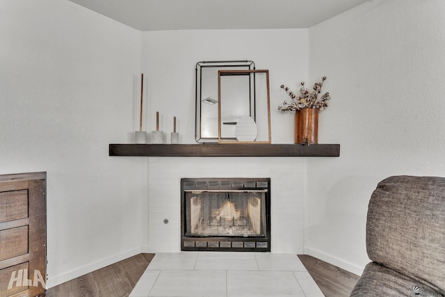 room details featuring a fireplace, baseboards, and wood finished floors