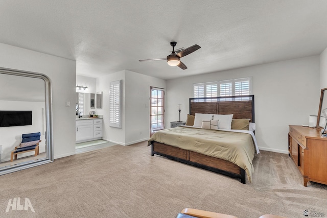 bedroom featuring light carpet, baseboards, and a textured ceiling