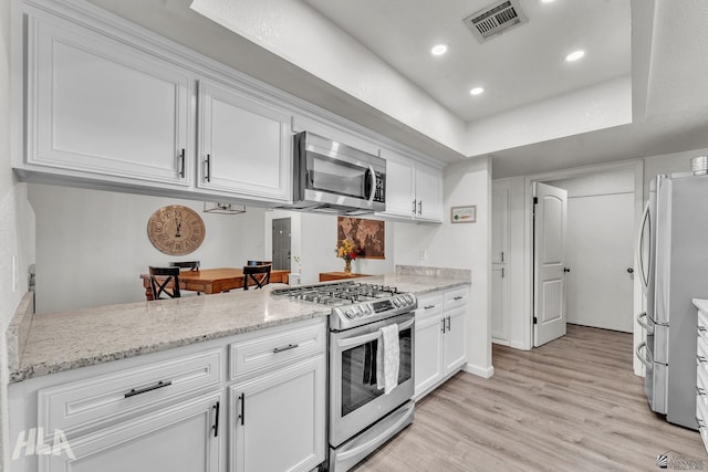 kitchen featuring light stone countertops, visible vents, appliances with stainless steel finishes, and white cabinets