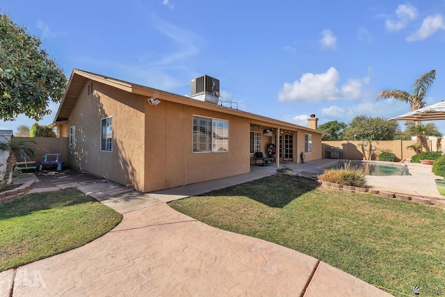 back of property featuring a fenced in pool, a patio, stucco siding, central AC, and a fenced backyard