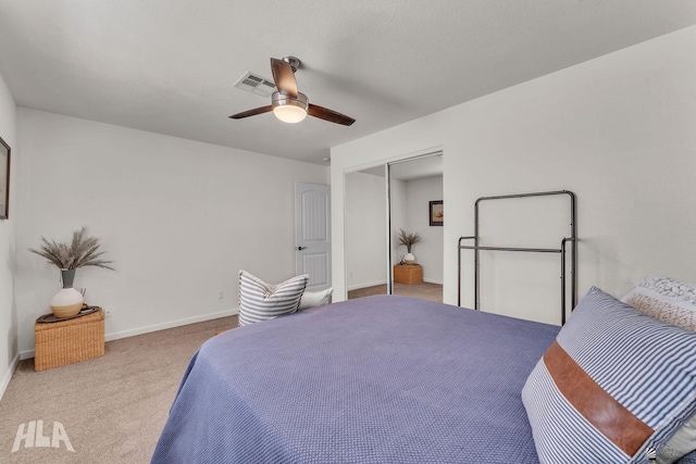 bedroom with a closet, visible vents, a ceiling fan, light carpet, and baseboards