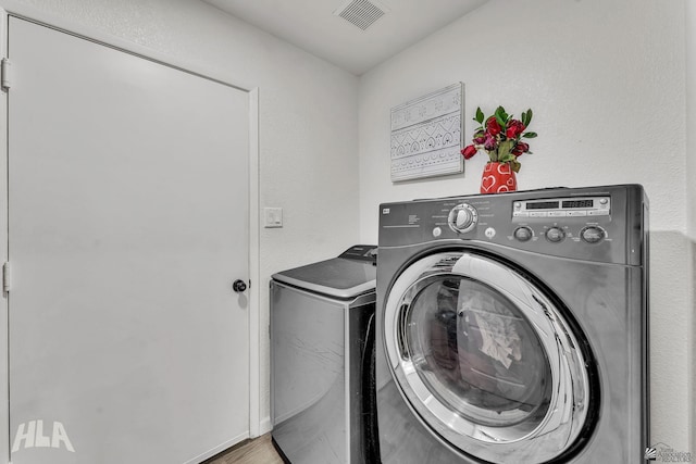 laundry room featuring laundry area, washing machine and dryer, and visible vents