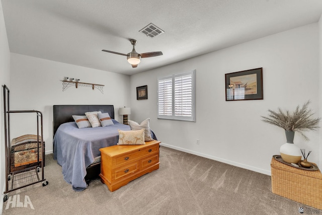 bedroom featuring ceiling fan, a textured ceiling, light colored carpet, visible vents, and baseboards