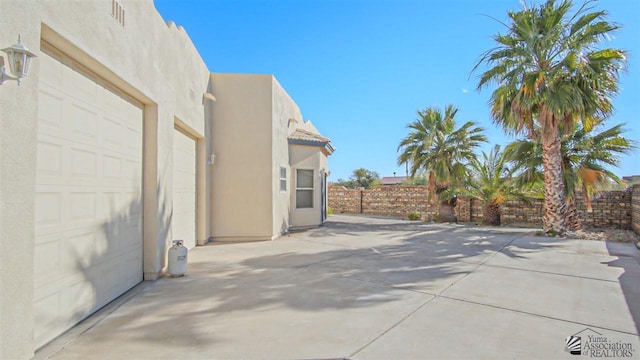 view of patio / terrace with an attached garage and visible vents