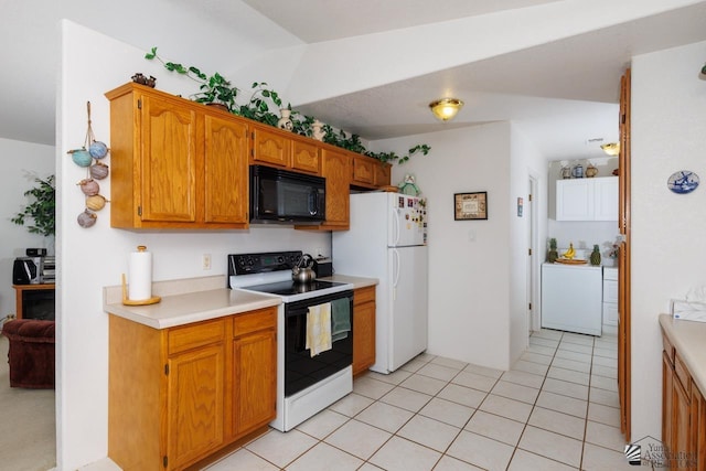 kitchen with vaulted ceiling, light tile patterned flooring, white appliances, and washer / dryer