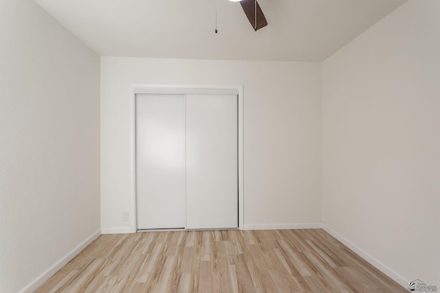 unfurnished bedroom featuring ceiling fan, a closet, and light hardwood / wood-style floors