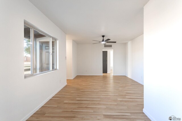 empty room with ceiling fan and light hardwood / wood-style floors