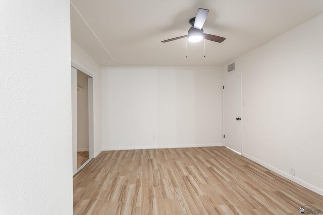 empty room with ceiling fan and light hardwood / wood-style floors