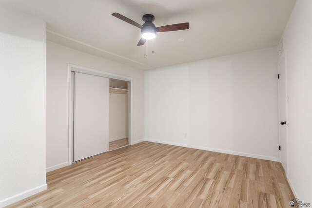 unfurnished bedroom with ceiling fan, a closet, and light wood-type flooring