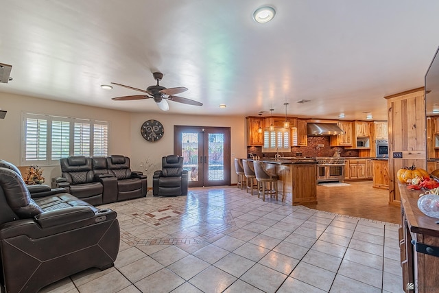 tiled living room featuring french doors, ceiling fan, and a healthy amount of sunlight